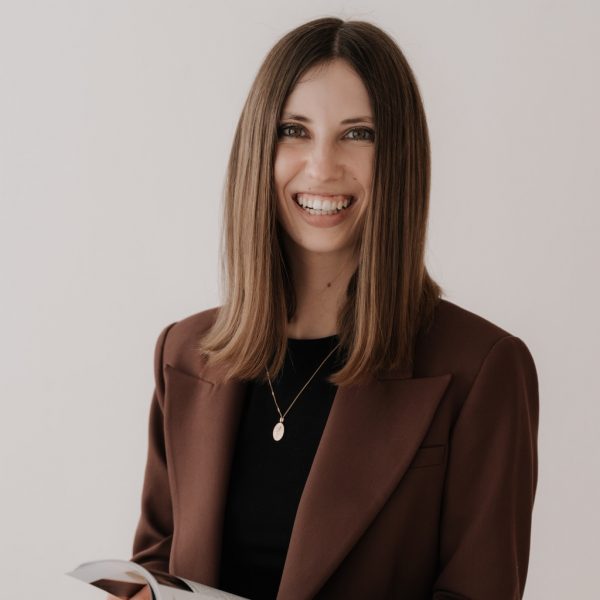 Judith Ladstätter hält Magazin in der Hand und lacht in die Kamera